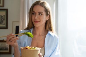 mujer de tiro medio comiendo tazon de salmon (1)
